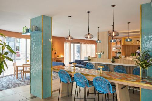 a kitchen and living room with a long table and chairs at Hotel Indigo Bordeaux Centre Chartrons by IHG in Bordeaux
