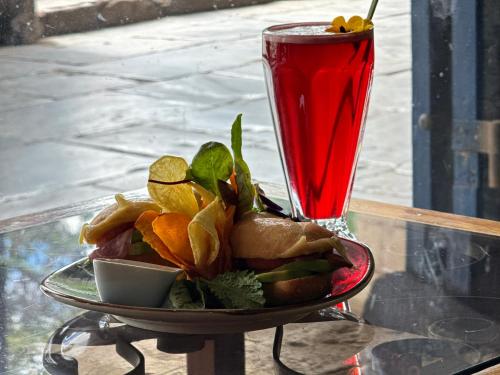 a plate of food on a table with a drink at Posada Villa Mayor in Cusco