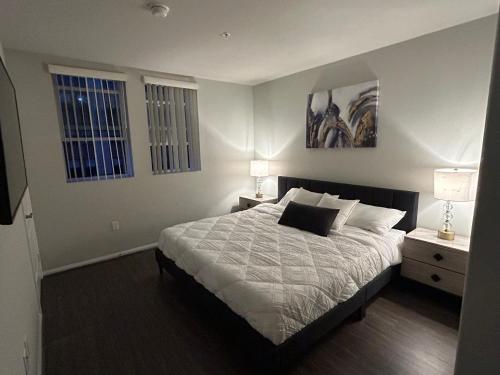 a bedroom with a bed with two lamps and two windows at 2 Bedroom Apartment Downtown LA! in Los Angeles