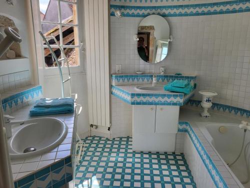 uma casa de banho azul e branca com um lavatório e uma banheira em Gîte Le Brethon, 5 pièces, 8 personnes - FR-1-489-217 em Le Brethon