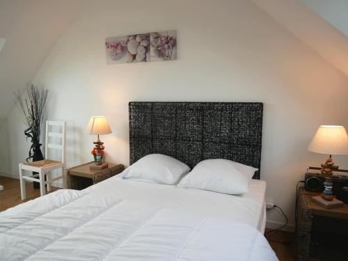 une chambre avec un grand lit blanc avec deux oreillers dans l'établissement Maison de vacances à Sarzeau, entre plages et golfe, calme et bien équipée - FR-1-639-27, à Sarzeau