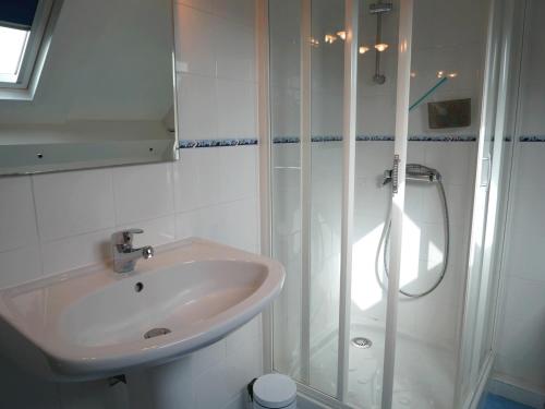 La salle de bains blanche est pourvue d'un lavabo et d'une douche. dans l'établissement Maison Sarzeau, 4 pièces, 8 personnes - FR-1-639-27, à Sarzeau