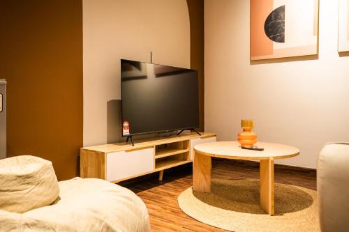 a living room with a tv and a table at K Avenue by Pinstay in Donggongon