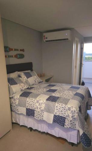 um quarto com uma cama com uma colcha azul e branca em Seja um hóspede de charme num flat-boutique a 80m do mar de Porto em Porto de Galinhas