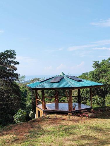 a gazebo with a blue roof on a hill at Yogachal Vista Mar Bamboo House in the Jungle in Ojochal