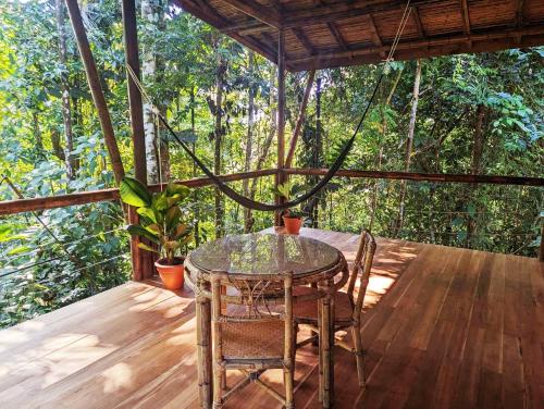 a patio with a table and chairs on a deck at Yogachal Vista Mar Bamboo House in the Jungle in Ojochal