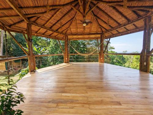 an empty pavilion with a wooden floor and trees at Yogachal Vista Mar Bamboo House in the Jungle in Ojochal