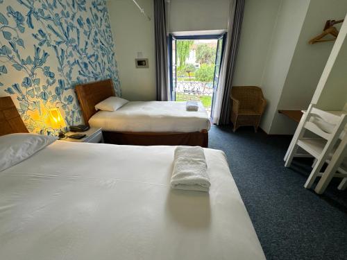 a hotel room with two beds and a window at Posada Villa Mayor in Cusco