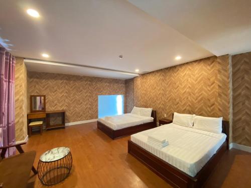 ein Schlafzimmer mit 2 Betten und einem TV in der Unterkunft FriendZoneS Hotel in Ấp Bình Hưng