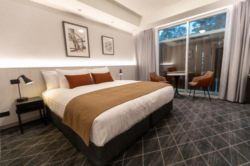 um quarto de hotel com uma cama grande e uma secretária em The Gable Inn em Scone