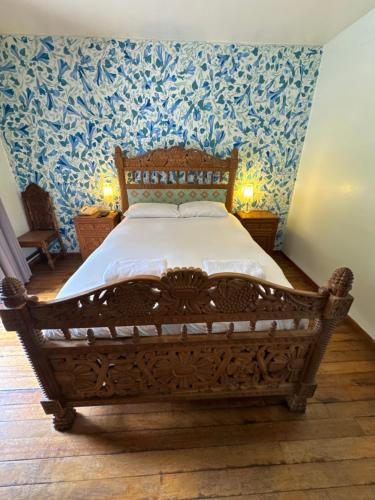 a bedroom with a wooden bed with blue wallpaper at Posada Villa Mayor in Cusco