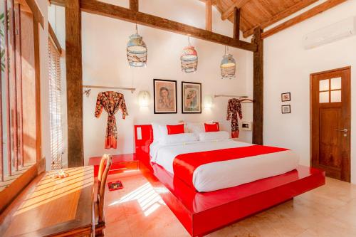 a bedroom with a red bed in a room at Bali Ginger Suites & Villa in Seminyak
