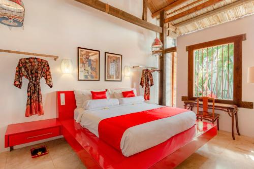 a bedroom with a red bed and a window at Bali Ginger Suites & Villa in Seminyak