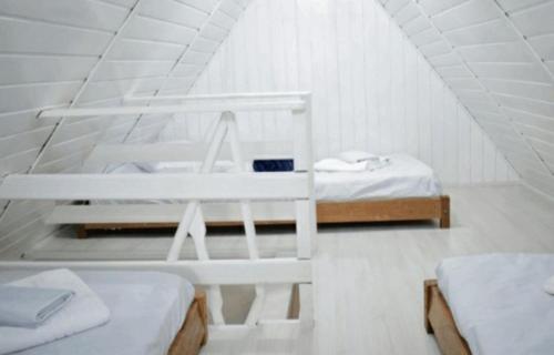 biały pokój z 2 łóżkami na poddaszu w obiekcie Lindo Chale em Águas de Lindoia w mieście Águas de Lindóia