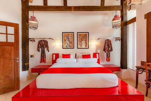 a bedroom with a red and white bed with red accents at Bali Ginger Suites & Villa in Seminyak