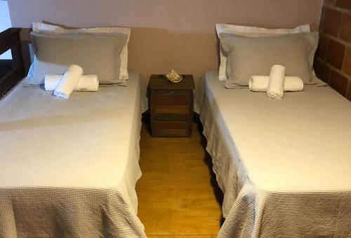 two beds sitting next to each other in a room at Casa de Praia - meu lugar em Iriri in Anchieta