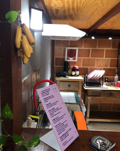a kitchen with a table with a sign on it at Casa de Praia - meu lugar em Iriri in Anchieta