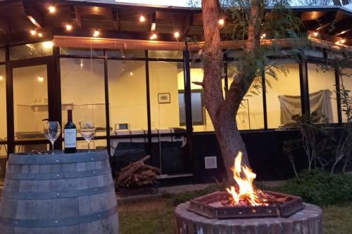 a fire pit with a tree in front of a building at Departamento con piscina en Vistalba in Vistalba