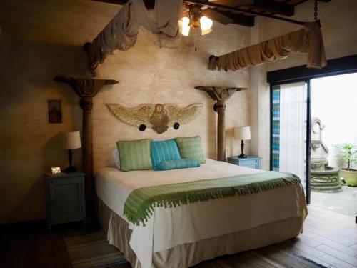 a bedroom with a bed with an owl head on the wall at Hotel Casa Madeleine B&B & Spa in Antigua Guatemala