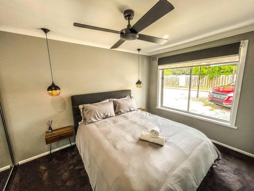 a bedroom with a bed with a ceiling fan and a window at Geelong West Unit in Geelong West