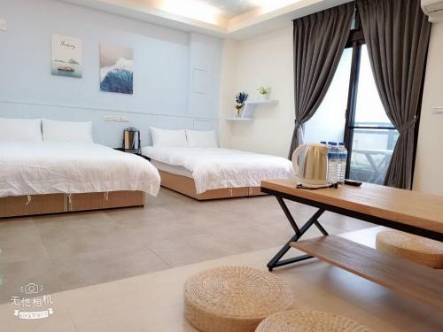 Habitación de hotel con 2 camas y mesa en 宜蘭頭城空空如也Kong Kong, en Toucheng