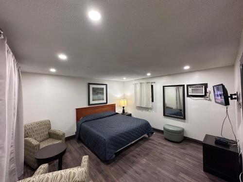 - une chambre avec un lit et une chaise dans l'établissement Cedar Springs Motel, à Acton