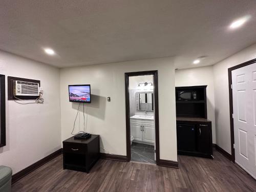 a living room with a television and a mirror at Cedar Springs Motel in Acton
