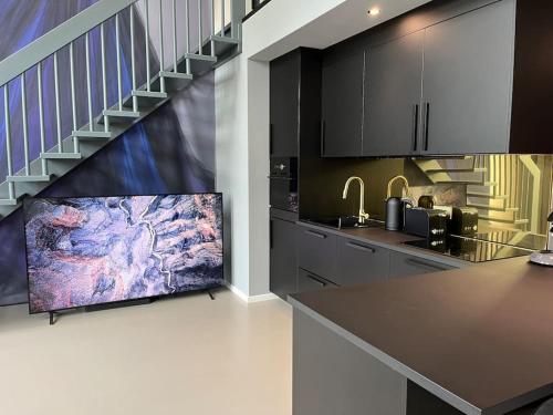 eine Küche mit einem großen TV und einer Treppe in der Unterkunft Duplex Loft mit Garten in Magdeburg