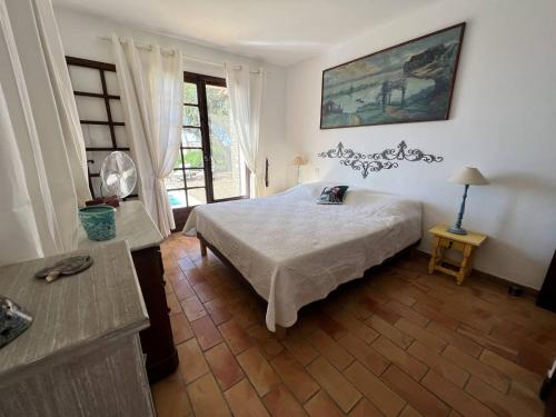 une chambre avec un lit, une table et une fenêtre dans l'établissement Maison 3 chambres avec piscine et vue sur mer - FR-1-726-33, à La Croix-Valmer