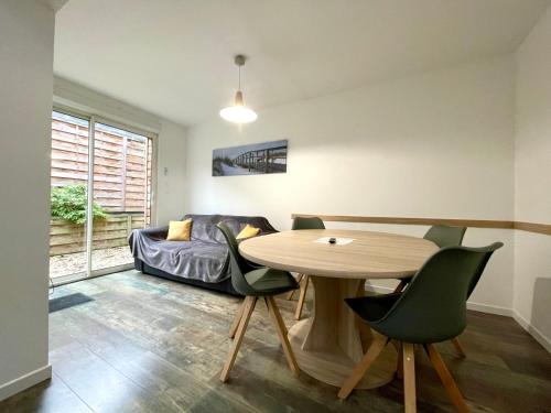 un salon avec une table, des chaises et un canapé dans l'établissement Résidence Duchenois, à Valenciennes