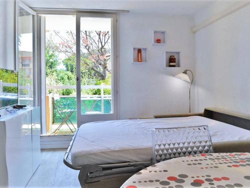 - une chambre avec un lit et une grande fenêtre dans l'établissement Appartement Bormes-les-Mimosas, 2 pièces, 4 personnes - FR-1-251-571, à Bormes-les-Mimosas