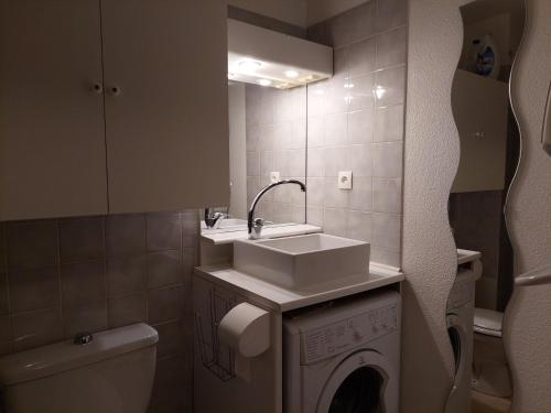 une salle de bain avec un lavabo et une machine à laver dans l'établissement Studio cosy à Brides-les-Bains, 4 pers, balcon, parking, proche thermes - FR-1-512-277, à Brides-les-Bains