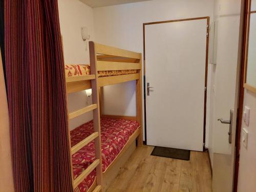 Cette petite chambre comprend 2 lits superposés et une porte. dans l'établissement Studio cosy à Brides-les-Bains, 4 pers, balcon, parking, proche thermes - FR-1-512-277, à Brides-les-Bains