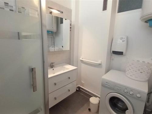 a white bathroom with a washing machine and a sink at Appartement Saint-Jean-de-Monts, 2 pièces, 5 personnes - FR-1-323-298 in Saint-Jean-de-Monts