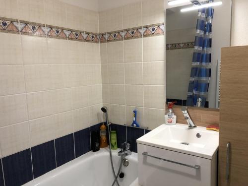 ein Badezimmer mit einer Badewanne, einem Waschbecken und einem Spiegel in der Unterkunft Appartement Bretignolles-sur-Mer, 3 pièces, 5 personnes - FR-1-231-296 in Brétignolles-sur-Mer