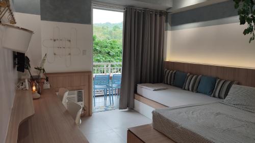 a bedroom with a bed and a balcony at Tu Casa at Pico de Loro in Nasugbu