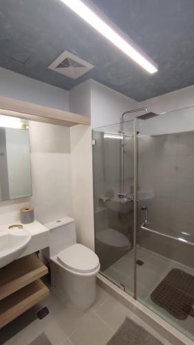 a bathroom with a toilet and a shower and a sink at Tu Casa at Pico de Loro - Myna B in Nasugbu
