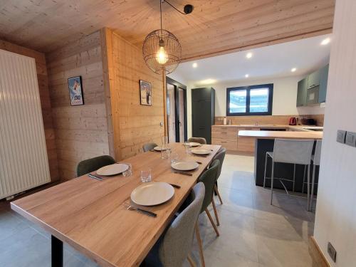 une salle à manger avec une grande table et des chaises en bois dans l'établissement Appartement rénové, lumineux et calme, au centre des Gets, proche pistes et commodités - FR-1-598-158, aux Gets