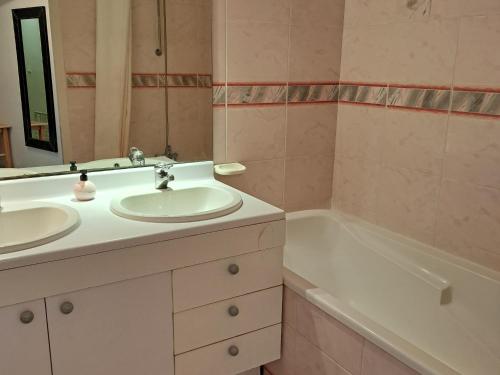 une salle de bain avec deux lavabos et une baignoire dans l'établissement Appartement spacieux 5 pers, front de mer, centre animations, balcon, animaux admis - FR-1-323-485, à Saint-Jean-de-Monts