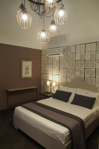 a bedroom with a large bed with lights above it at Terrazzani Suite in Comiso