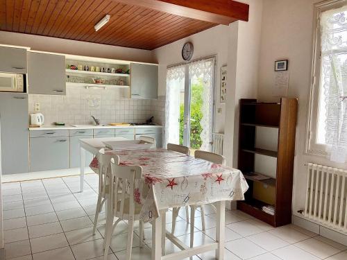 une cuisine avec une table et des chaises dans l'établissement Maison de Pays avec Grand Jardin, Proche Centre et Plage - FR-1-231-294, à Bretignolles-sur-Mer