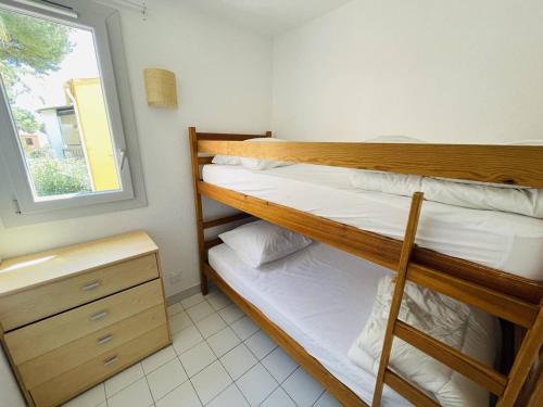 deux lits superposés dans une chambre avec fenêtre dans l'établissement Appartement avec piscine, tennis, clim, parking et wifi au Cap d'Agde - FR-1-723-118, au Cap d'Agde