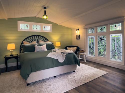 a bedroom with a bed and two windows at Bundanoon Garden Retreat in Bundanoon