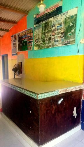 a counter in a restaurant with posters on the wall at bulan homestay in Plambi