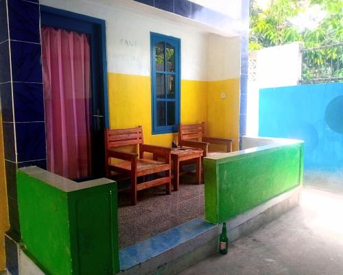 a room with chairs and a table and a door at bulan homestay in Plambi