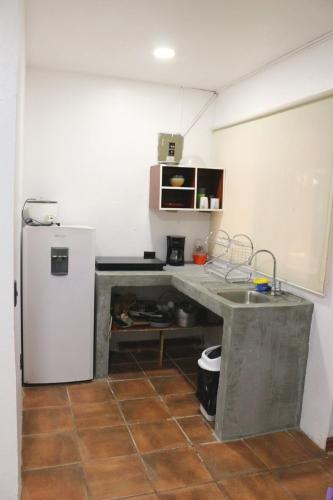 a kitchen with a desk and a refrigerator at Coconut Beach House in Playa Conchal