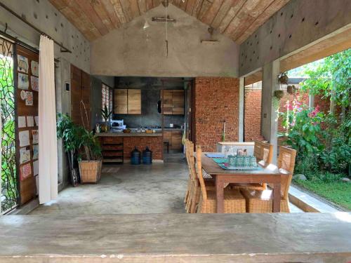 a kitchen with a wooden table and a dining room at Villa di Bukit Lawang: LocalDailyLife, near Jungle in Bukit Lawang
