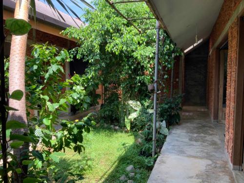 a garden outside a house with a greenhouse at Villa di Bukit Lawang: LocalDailyLife, near Jungle in Bukit Lawang
