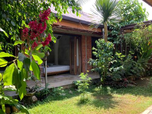 a guest house with a bed in a garden at Villa di Bukit Lawang: LocalDailyLife, near Jungle in Bukit Lawang