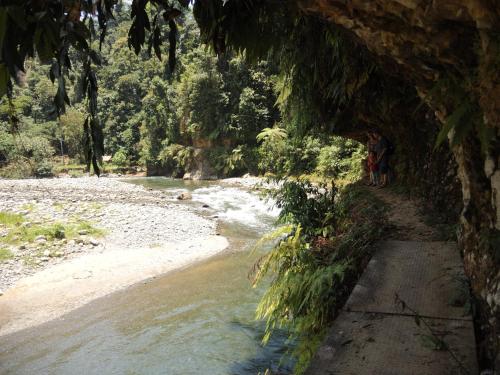 a group of people walking down a path next to a river at Villa di Bukit Lawang: LocalDailyLife, near Jungle in Bukit Lawang
